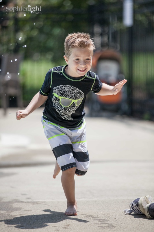 Must-have photos of your child during summer. Boy running by the pool away from splashing.